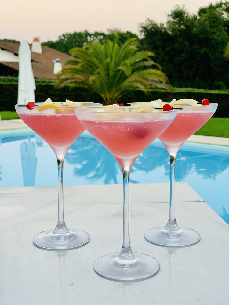 Verres à cocktail rose au bord de la piscine