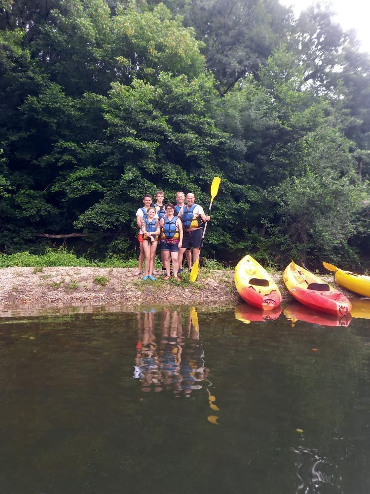 Famille sur la rive devant des canoë-kayaks