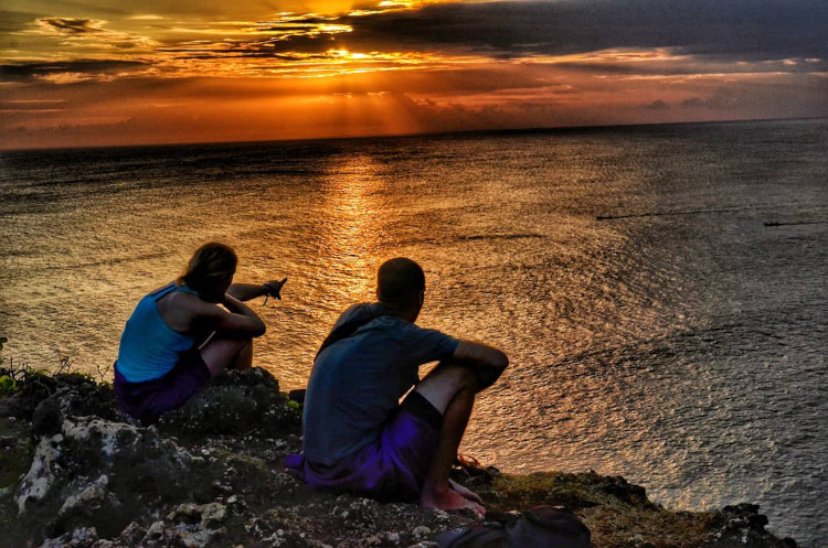 Personnes devant un coucher de soleil