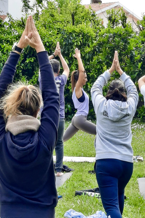 Photographie de Pauline Cistacq en pleine démonstration, entourée de ses élèves pendant ses cours de yoga. 